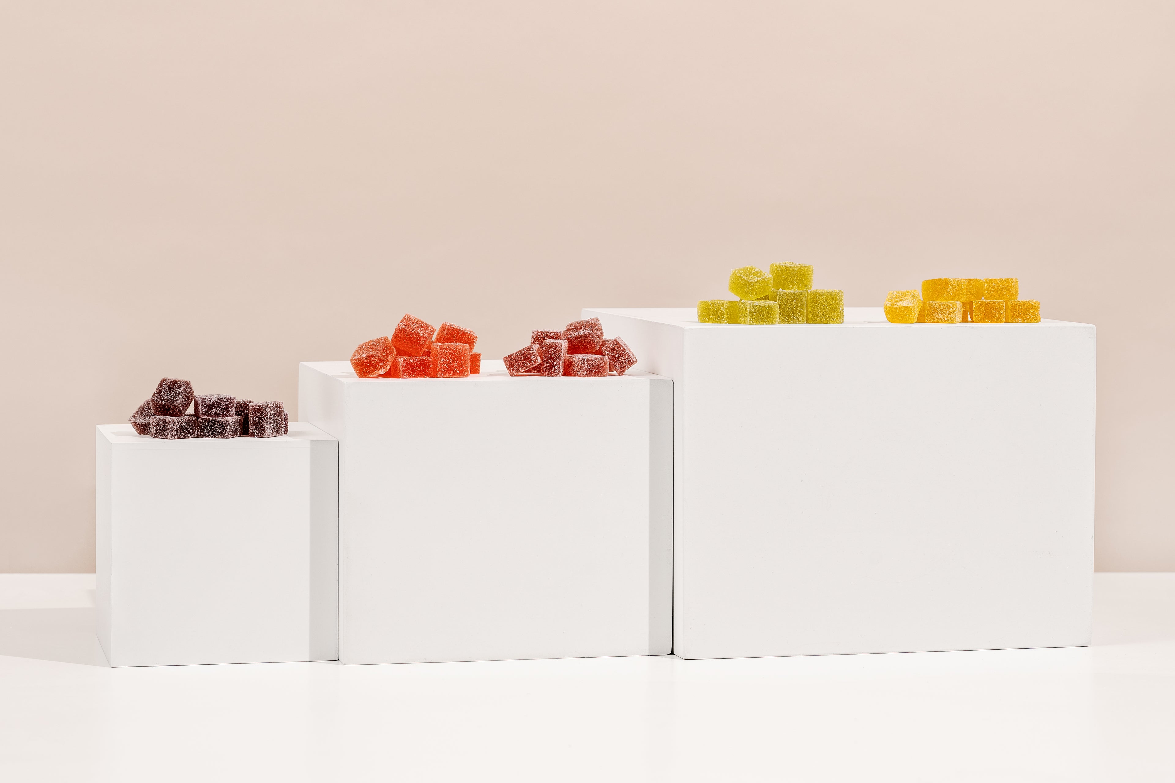 Display of various Honey Bloom gummies on a white surface from least to most potent